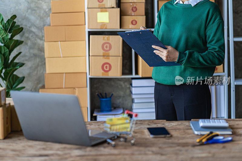 Small Business Startup SME Owner Asian Woman Checking Online Orders Sell ​​goods, work with boxes. home office freelance work online sme business delivery concept